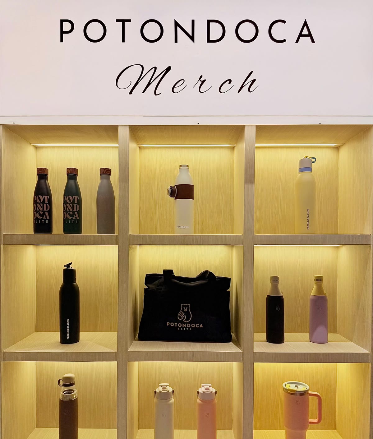 Rak display merchandise Potondoca Elite — botol minum dan tote bag